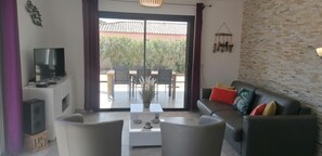 A living room with a sofa, coffee table, and TV. - VILLA LES PINS DE BONIFACIO (BONIFACIO)