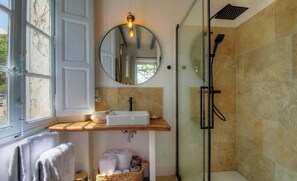 Ein Badezimmer mit Waschbecken, Spiegel und Dusche.