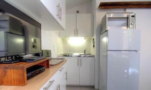 A kitchen with a microwave, refrigerator, wooden counter, and cabinets. - Tilleul 1 - COSTA - Gîte (COSTA)