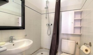 A bathroom with a sink, toilet, shower, and a mirror. - Tilleul 1 - COSTA - Gîte (COSTA)
