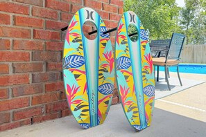 Two surfboards leaning against a brick wall.