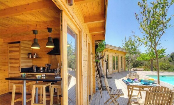 Eine Holzhütte mit Küche, Essbereich und Pool.