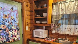 Una cocina con armarios de madera, un microondas y un lavabo.