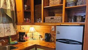 Una cocina con armarios de madera, un refrigerador, un fregadero y diversos electrodomésticos.