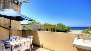 A patio with a table and chairs, a blue umbrella, and a view of the sea. - Mare e Torre - FARINOLE (FARINOLE)