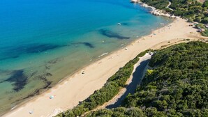 An aerial view of a beach with clear waters, a sandy shore, and dense greenery on the hillside. - Mare e Torre - FARINOLE (FARINOLE)