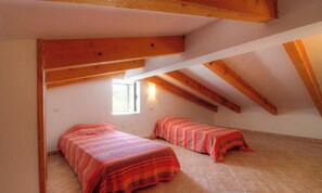 A room with two beds, wooden beams, a window, and tiled flooring. - Quarcioli - BOCOGNANO (BOCOGNANO)