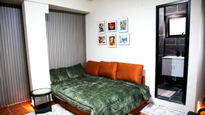 Un dormitorio con cama, una mesita, un armario y una ventana.