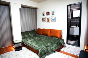 A bedroom with a bed, a small table, a wardrobe, and a window.