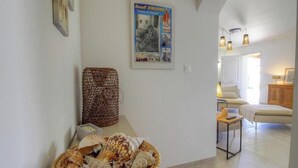 Una stanza con un letto, un tavolino con una lampada, un poster appeso al muro e un cesto di vimini.