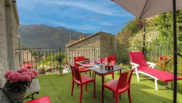 A terrace with a table and chairs, a swing chair, and a view of mountains. - Nanu - AULLENE - Gîte (AULLENE)
