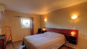 A bedroom with a bed, bedside lamps, a window, and a chair. - U Castagnu 2 - EVISA (EVISA)
