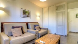 A room with two sofas, a wooden coffee table, a framed picture on the wall, and a white door. - U Castagnu 2 - EVISA (EVISA)