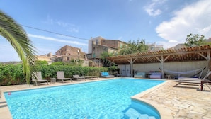 A swimming pool with lounge chairs, a hammock, and a covered seating area. - A Torra - CATERI - Gîte (CATERI)