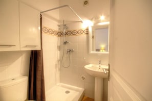 Ein Badezimmer mit Dusche, Toilette und Waschbecken.