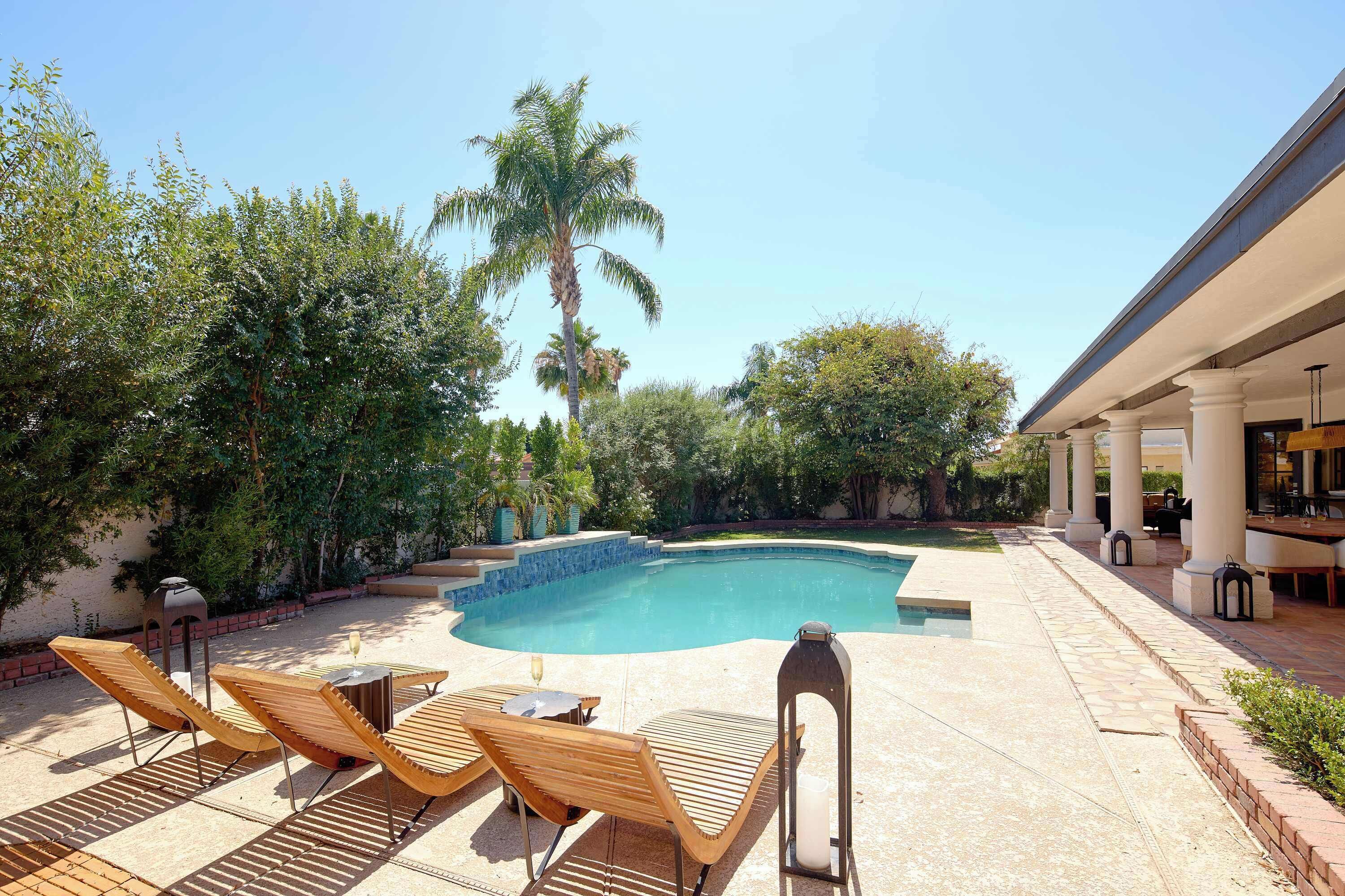 A swimming pool with lounge chairs and a patio area.