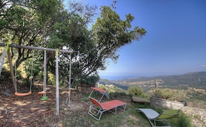 A patio with a swing set, a table, and chairs, overlooking a scenic landscape. - Appulatoddiu - CANNELLE D'ORCINO (CANNELLE D'ORCINO)