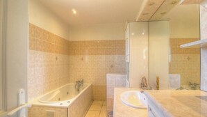 Ein Badezimmer mit einer Badewanne, einem Waschbecken und einem Spiegel.
