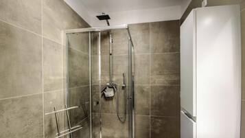 Een douche met een glazen deur, een handdouche en een wandmengkraan.