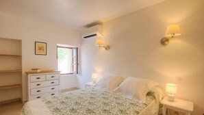 A bedroom with a bed, bedside lamps, a window, a dresser, and an air conditioning unit. - Capu D'ortu - PIANA - Gîte (PIANA)