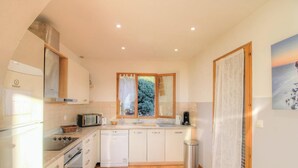 Una cocina funcional con ventana, pileta, cocina y lavavajillas.