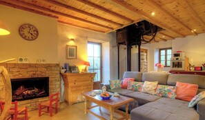 Ein gemütliches Wohnzimmer mit Kamin, Sofa, Couchtisch und Holzboden.