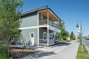 A two-story building with a porch, a sign reading 'Timberline Collection,' and a street lamp. - Spruce @ Timberline Flats (Traverse City)