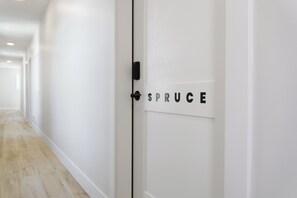 Een gang met een witte deur met daarop de tekst 'SPRUCE'.
