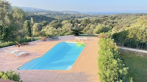 Ein Schwimmbad mit Blick auf eine hügelige Landschaft.