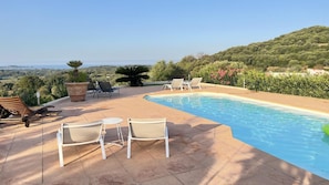 Ein Pool mit Liegestühlen und Blick auf die Landschaft.