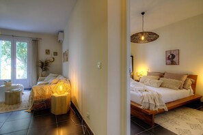 Ein Schlafzimmer mit Bett, Nachttischlampen, einem Fenster und einer Tür.