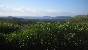 Eine Küstenlandschaft mit Blick auf das Meer und ferne Hügel.