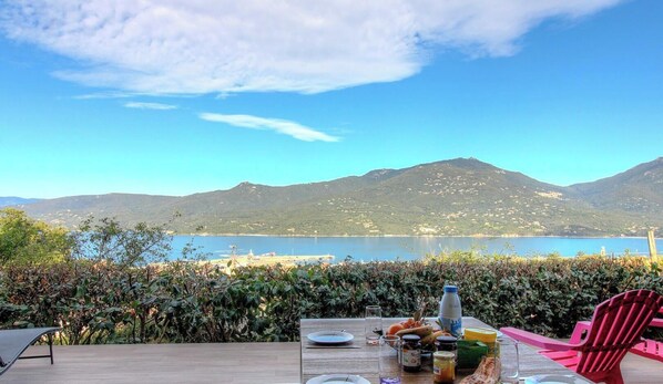 Ein Tisch im Freien mit Blick auf einen See und Berge.