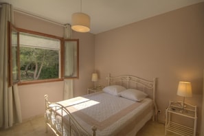 A bedroom with a bed, a window, a bedside table, and a lamp. - A TORRA - FARINOLE - Gîte (FARINOLE)