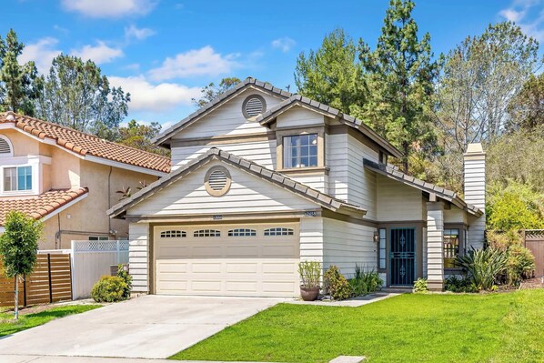 A two-story house with a garage, a front yard, and a driveway. - Bright Carmel Valley Home - 3BR, BIG YARD (San Diego)