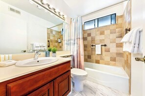 A bathroom with a sink, mirror, vanity, toilet, and bathtub. - Bright Carmel Valley Home - 3BR, BIG YARD (San Diego)