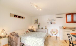 Ein Schlafzimmer mit Bett, Nachttisch, Lampe und Stuhl.