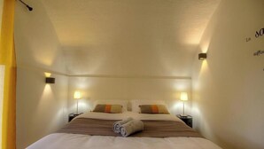 A hotel room with a bed, two bedside tables, and wall-mounted lamps. - Casetta Anghjulina - CASTIFAO (CASTIFAO)