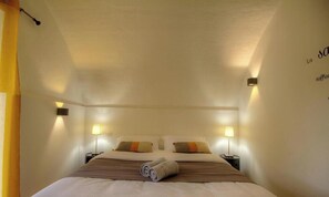 Ein Hotelzimmer mit einem Bett, zwei Nachttischen und Wandlampen.