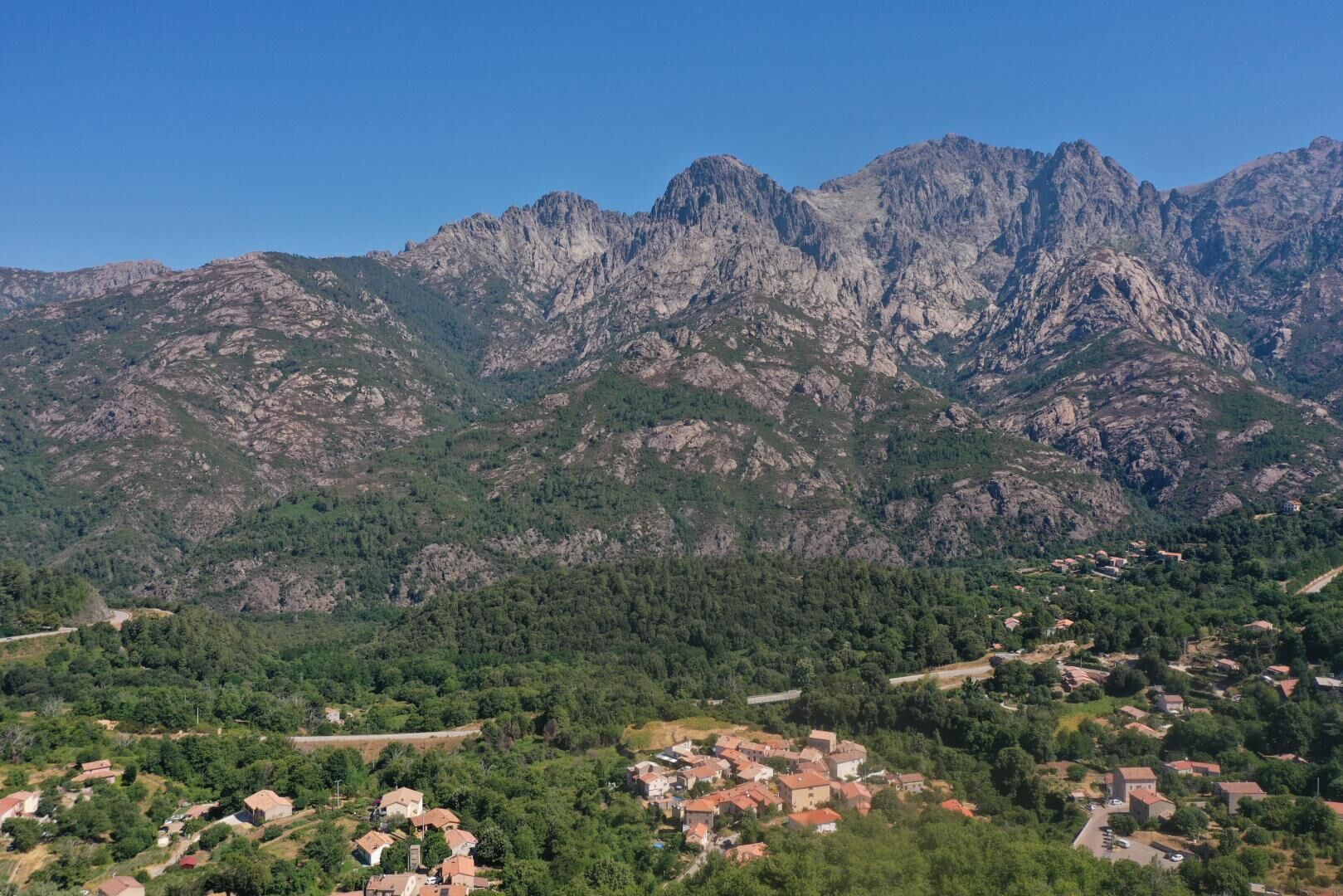 Un paysage montagneux avec un village au premier plan.