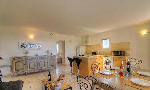 A spacious living area with a dining table set for two, a kitchen with modern appliances, and a decorative cabinet. - U Listincu - VIGGIANELLO (VIGGIANELLO)