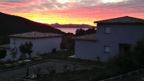 Un barrio residencial con casas, cielo despejado y un atardecer.