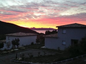 Ein Wohngebiet mit Häusern, wolkenlosem Himmel und Sonnenuntergang.