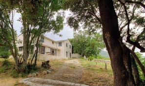 A house with a paved driveway, surrounded by trees and a mountain in the background. - Santa Maria - SISCO - Gîte (SISCO)