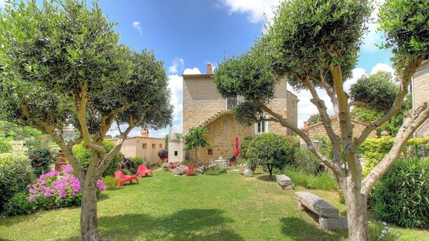 A stone building with a garden, red chairs, and a clear sky. - Le 22401 - PETRETO BICCHISANO (PETRETO BICCHISANO)
