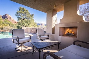 An outdoor patio with a pool, chairs, a table, and a fireplace. - Rolling Sedona Paradise 4 Bdrm, 4.5 BA, Pool (Sedona)