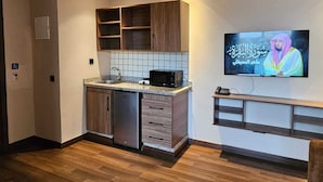 A modern kitchen with wooden cabinets, a built-in microwave, and a tiled backsplash. - OCEAN ROOFTOP HOTEL (El Mansouria)