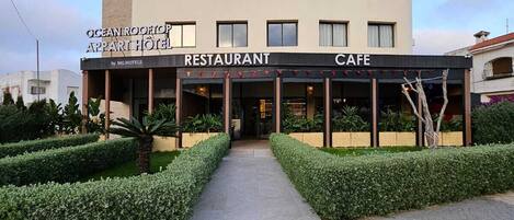 A building with a sign for 'Ocean Rooftop Apartments Hotel Restaurant Cafe' by MG Hotels.