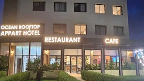 A multi-story building with 'OCEAN ROOFTOP APART HOTEL' signage, a restaurant, and a cafe. - OCEAN ROOFTOP HOTEL (El Mansouria)