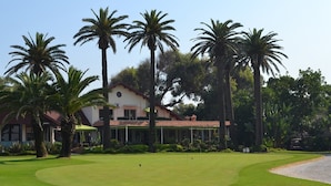 A golf course with a building in the background. - OCEAN ROOFTOP HOTEL (El Mansouria)